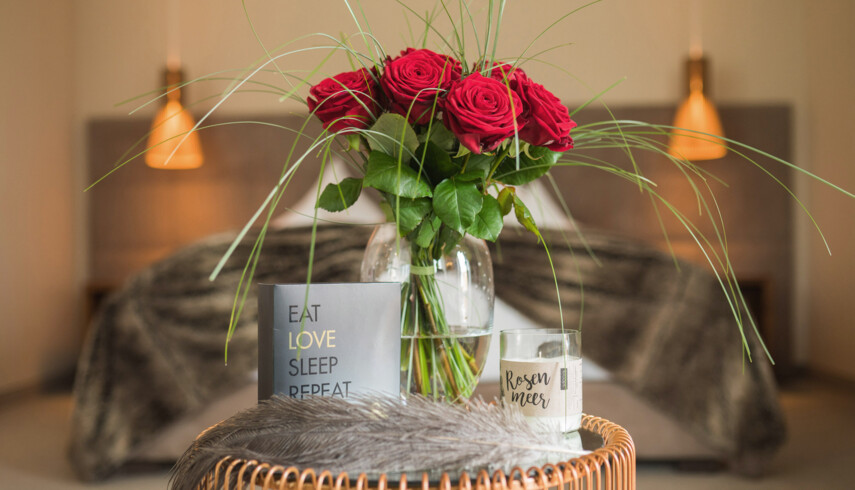 Beim Romantikwochenende in Salzburg wartet ein Strauß Roter rosen im Hotelzimmer