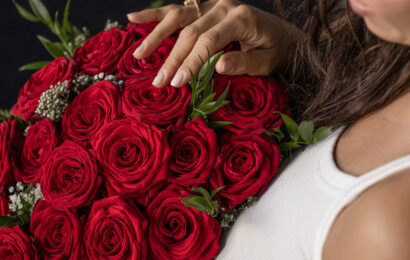 Eine Frau hält einen Strauß roter Rosen