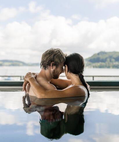 Ein Paar genießt im Pool die Zweisamkeit im 4-Nächte-Urlaub in Österreich 
