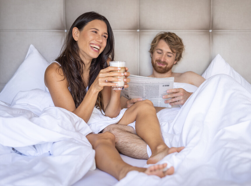 Ein Paar genießt den Morgen im Hotelbett