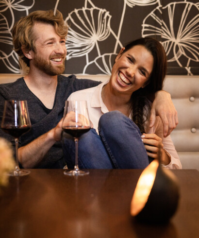 Beim Liebeswochenende in Österreich genießt ein Paar ein Glas Rotwein