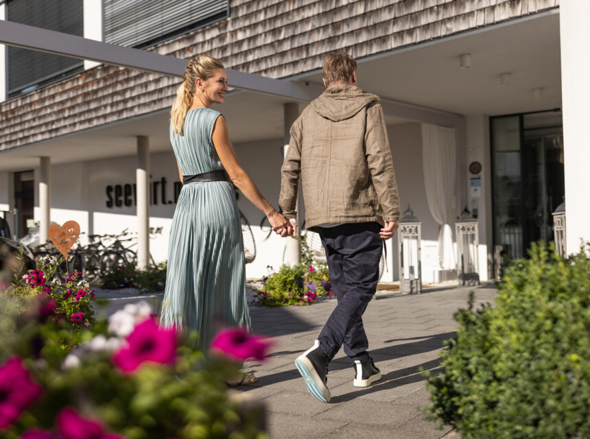 Ein Paar spaziert auf das Hotel Seewirt Mattsee zu