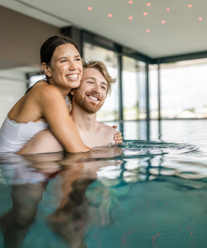 Ein Paar genießt im Pool die Zweisamkeit im 4-Nächte-Urlaub in Österreich 