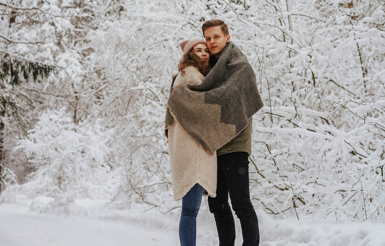 Ein Paar umarmt sich in verschneiter Landschaft