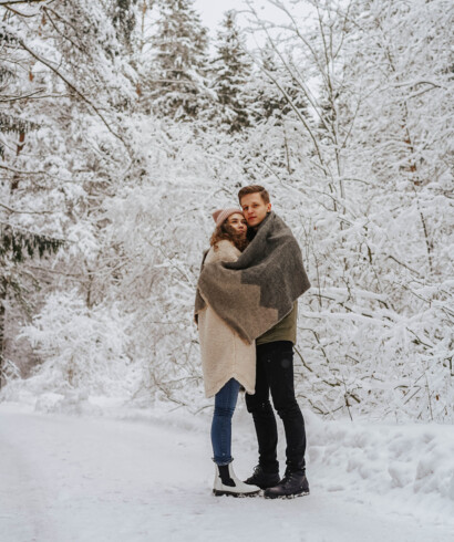 Ein junges Paar umarmt sich in winterlicher Umgebung am See