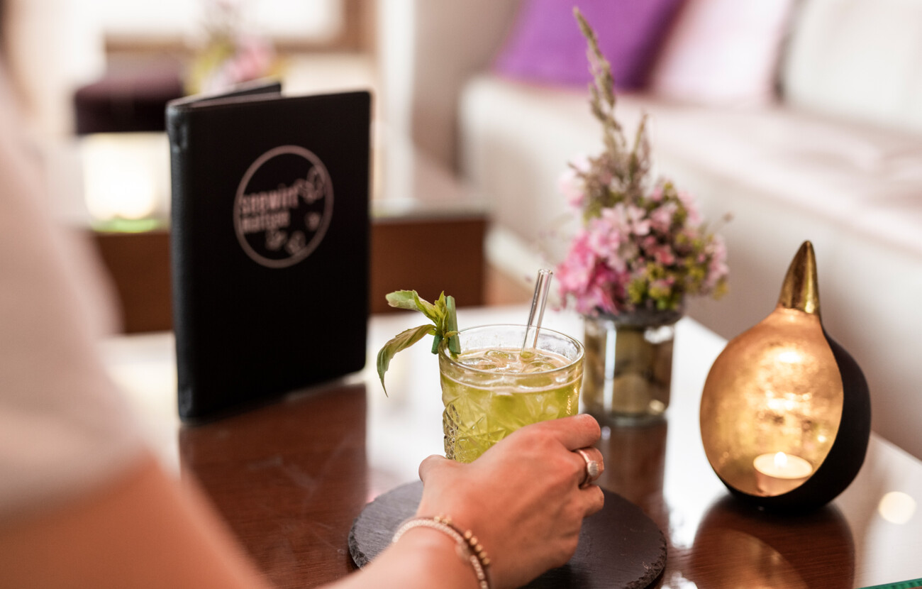 Eine Frau genehmigt sich einen Cocktail in der Lounge
