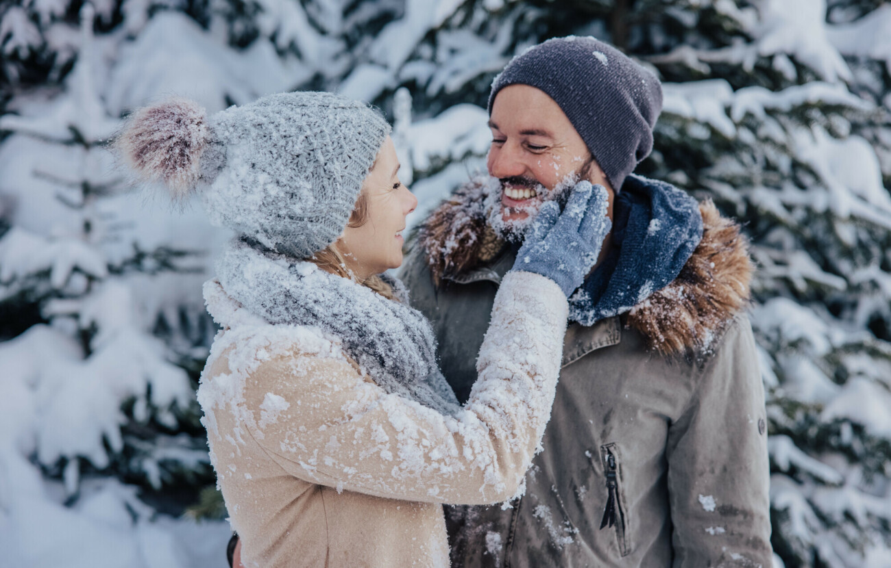 Ein Paar sieht sich beim Winterspaziergang verliebt an