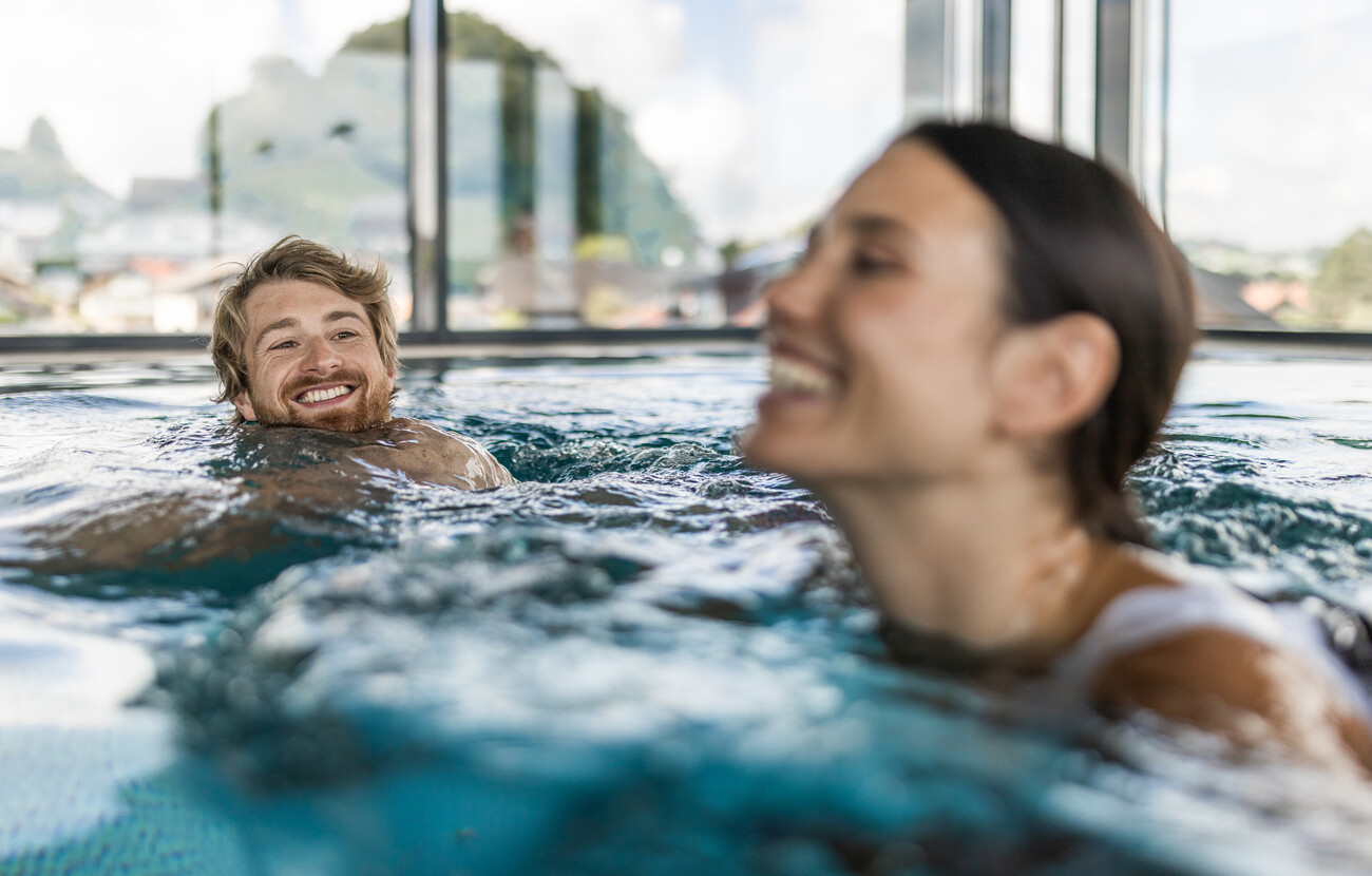 Ein Paar schwimmt im Pool des Hotels Seewirt Mattsee