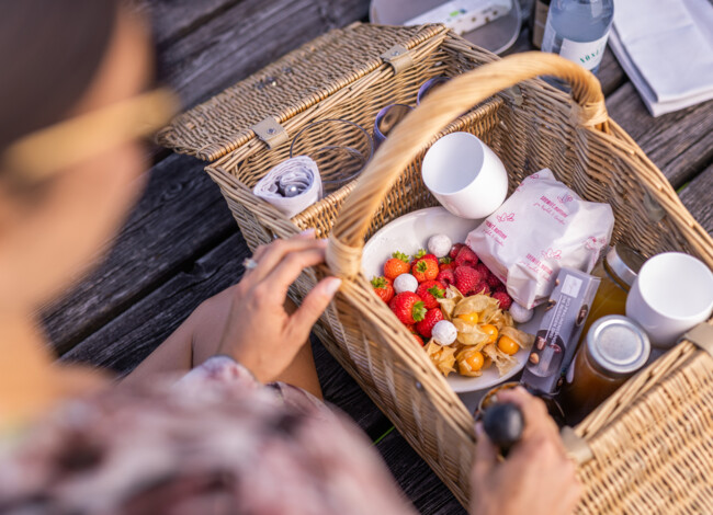 Eine Frau öffnet einen Picknickkorb