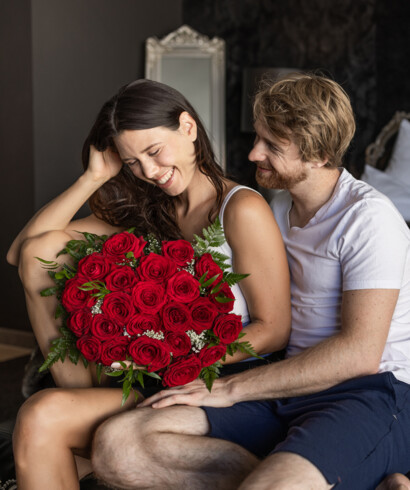 Eine junge Frau freut sich über einen Strauß roter Rosen