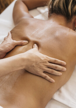 Im Hotel mit SPA bei Salzburg lässt sich eine Frau den Rücken massieren