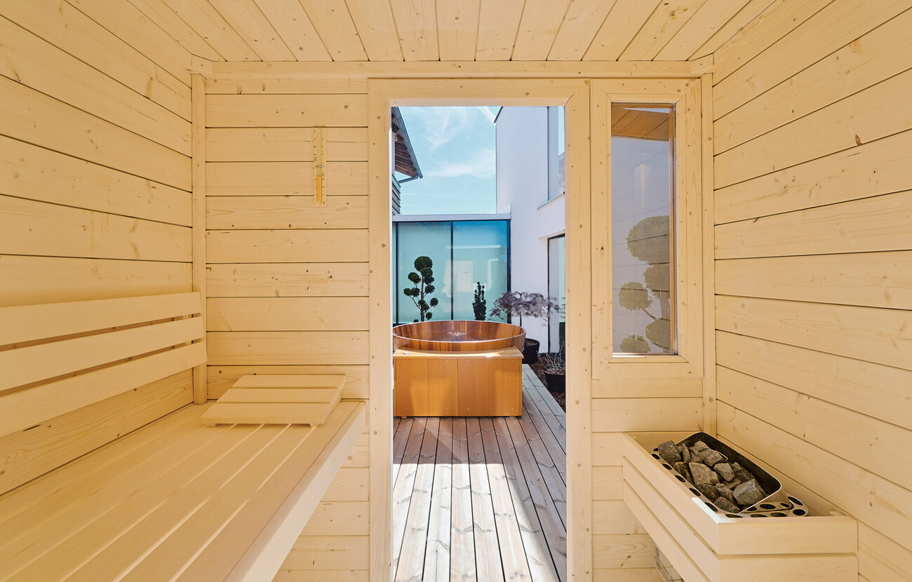 Ausblick aus der Sauna auf den Badezuber der privaten SPA-Terrasse
