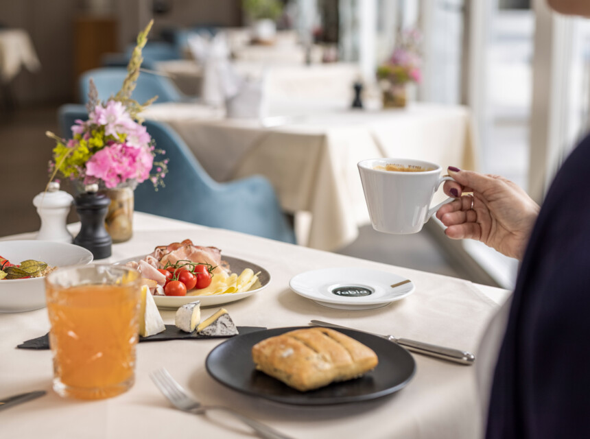 Eine Frau genießt das Frühstück im Hotel Seewirt Mattsee