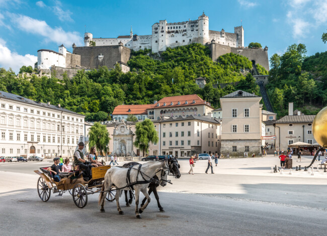 Eine Kutsche fährt über den Kapitelplatz in Salzburg